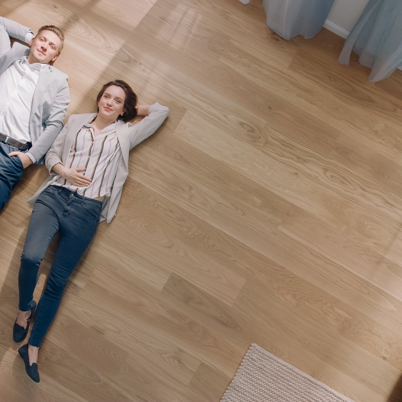 couple laying on vinyl floor in house