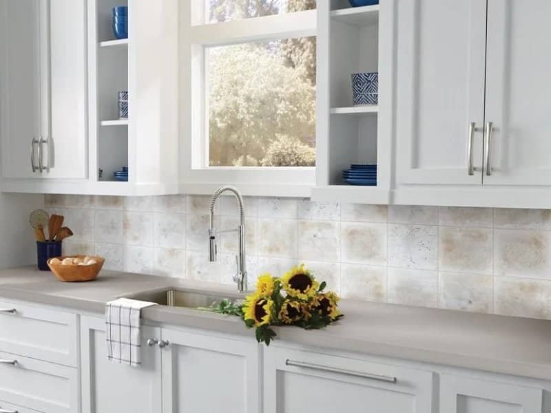 white cabinetry kitchen with flowers on the grey countertop